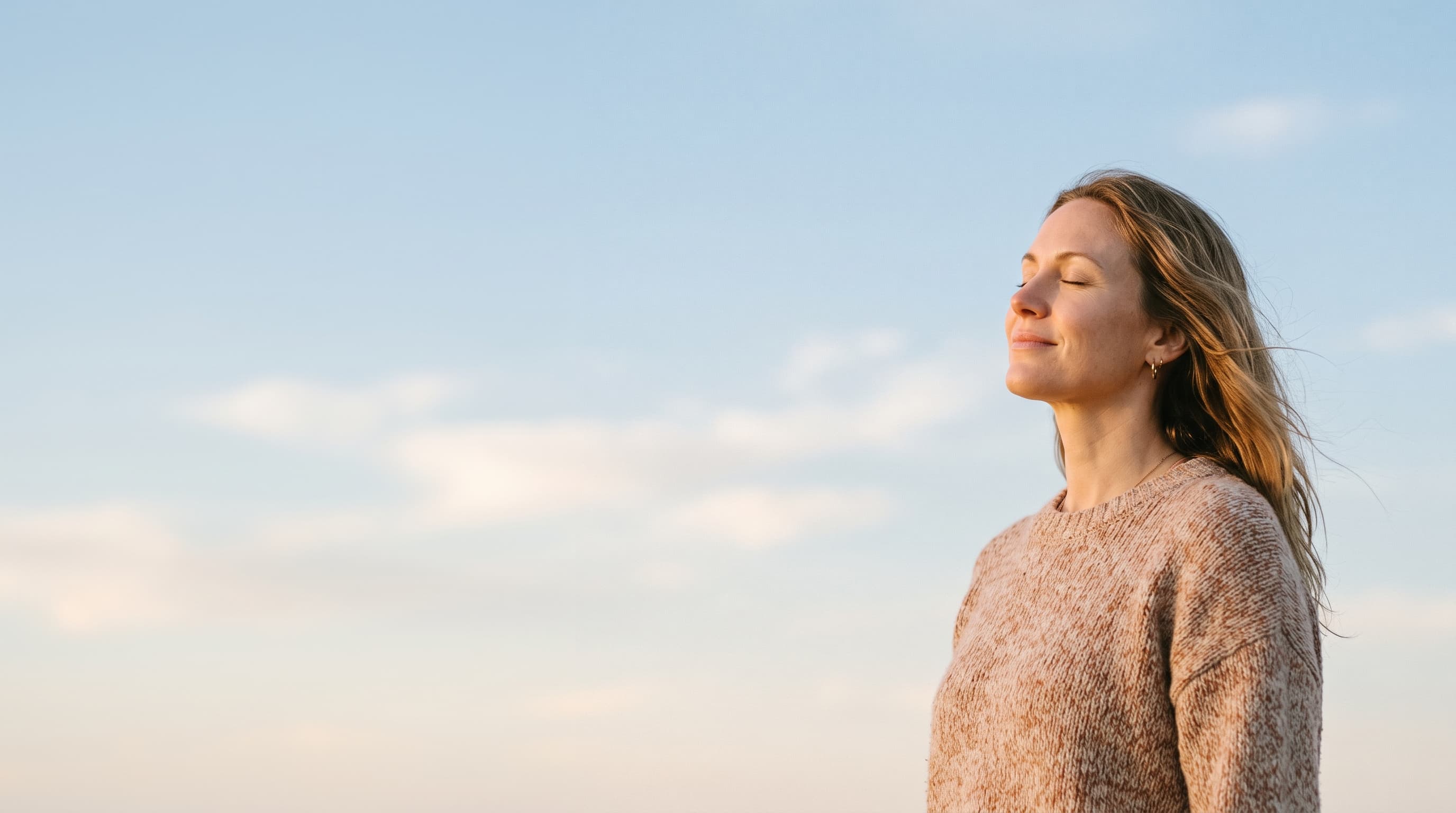 A woman resting in soft daylight, eyes closed and calm